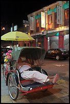 Driver taking nap in trishaw at night. George Town, Penang, Malaysia (color)