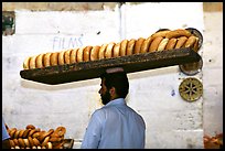Man carrying many loafes of bread on his head. Jerusalem, Israel (color)