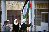 Women raise the Palestian flag at a school in East Jerusalem. Jerusalem, Israel (color)