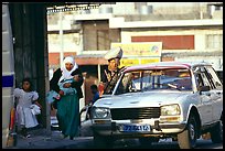 Women next to an old French Peugeot car, Hebron. West Bank, Occupied Territories (Israel) (color)