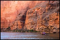 Oar raft below sheet Redwall limestone canyon walls. Grand Canyon National Park, Arizona
