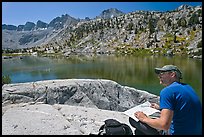 Hiker with map near lake, lower Dusy Basin. Kings Canyon National Park, California (color)