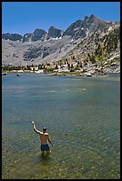 Man standing in alpine lake, lower Dusy Basin. Kings Canyon National Park, California