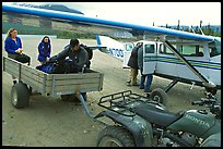 Unloading the gear from the plane to a trailer on the Port Alsworth airstrip. Lake Clark National Park, Alaska (color)