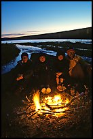 Campers warming toes in campfire next to Turquoise Lake. Lake Clark National Park, Alaska