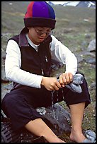 Woman backpacker drying socks after a stream crossing. Lake Clark National Park, Alaska (color)