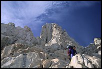 Looking up to woman scrambling on rocks on the East face of Mt Whitney. Sequoia National Park, California (color)