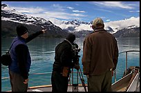 Crew filming from the deck of a boat. Glacier Bay National Park, Alaska, USA. (color)