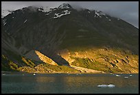 Sunset light falling on the base of the peaks around Tarr Inlet. Glacier Bay National Park, Alaska, USA.
