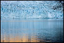 Golden reflections and blue ice of Margerie Glacier. Glacier Bay National Park, Alaska, USA.