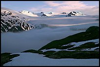 Low clouds, partly melted snow cover, and mountains. Kenai Fjords National Park, Alaska, USA.