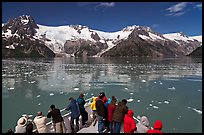 People looking at glaciers as boat crosses ice-chocked waters, Northwestern Fjord. Kenai Fjords National Park, Alaska, USA. (color)