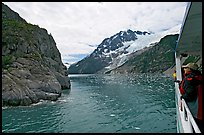 Passenger on small tour boat, island and glacier, Northwestern Fjord. Kenai Fjords National Park, Alaska, USA.
