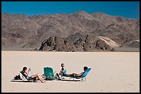 Tourists sunning themselves with beach chairs on the Racetrack. Death Valley National Park, California, USA. (color)