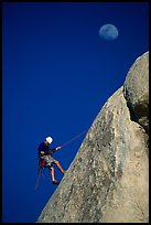 Climber rappelling down with moon. Joshua Tree National Park, California, USA. (color)