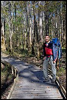 Hiker with backpack standing on boardwalk. Congaree National Park, South Carolina, USA.