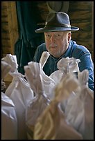 Miller sitting behind bags of cornmeal, North Carolina. Great Smoky Mountains National Park, USA. (color)