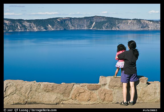 Woman and baby looking at Crater Lake. Crater Lake National Park, Oregon, USA.
