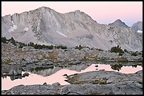 Mountains reflected in calm alpine lake at dawn, Dusy Basin. Kings Canyon National Park, California, USA.