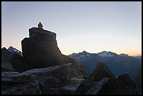 Man sitting on rock contemplates mountains at sunrise, North Cascades National Park.  ( color)