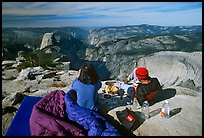Backpackers eat breakfast, looking at Yosemite Valley from Clouds Rest. Yosemite National Park, California, USA. (color)