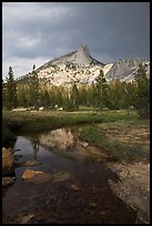 Cathedral Peak reflected in stream under stormy skies. Yosemite National Park, California, USA.