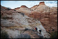 Hikers climbing out of High Spur slot canyon, Orange Cliffs Unit, Glen Canyon National Recreation Area, Utah. USA ( color)