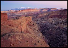 Waterpocket Fold and snowy mountains at dusk. Capitol Reef National Park, Utah, USA.