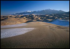 Sand dunes with snow patches and Sangre de Christo range. Great Sand Dunes National Park and Preserve, Colorado, USA.
