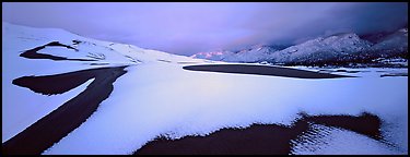 Snow-covered dune landscape and mountains at dawn. Great Sand Dunes National Park and Preserve (Panoramic color)