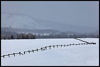 Wooden fence, snow-covered flat, hills in winter. Grand Teton National Park, Wyoming, USA. (color)