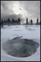 Thermal pool and dark clouds, winter. Yellowstone National Park, Wyoming, USA. (color)