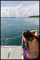 Woman relaxes on snorkeling boat as it enters Caesar Creek. Biscayne National Park, Florida, USA. (color)