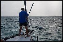 Sailor getting ready to hook mooring buoy near Loggerhead Key. Dry Tortugas National Park, Florida, USA. (color)