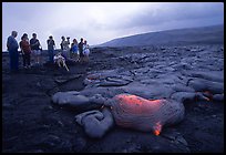 Hikers observe a live lava flow at close distance. Hawaii Volcanoes National Park, Hawaii, USA. (color)