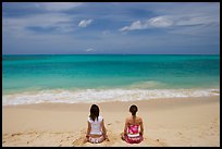 Young women facing ocean in meditative pose on Waimanalo Beach. Oahu island, Hawaii, USA ( color)
