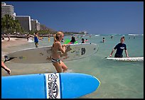 Surfers entering the water with boards, Waikiki Beach. Waikiki, Honolulu, Oahu island, Hawaii, USA (color)
