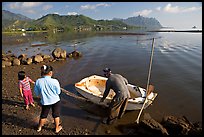 Fisherman and family pulling out net out of small baot, Kaneohe Bay, morning. Oahu island, Hawaii, USA (color)