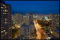 Boulevard and high-rise towers at dusk. Waikiki, Honolulu, Oahu island, Hawaii, USA