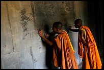 Two buddhist monks examine  bas-reliefs in Angkor Wat. Angkor, Cambodia