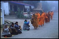 Women line up to offer alm to buddhist monks. Luang Prabang, Laos (color)