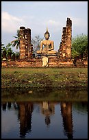 Buddha image reflected in moat, morning, Wat Mahathat. Sukothai, Thailand (color)