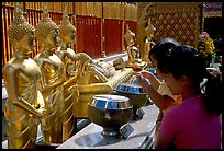 Worshiper makes offering at Wat Phra That Doi Suthep. Chiang Mai, Thailand (color)