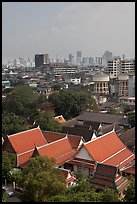 Temple rooftop and modern skyline. Bangkok, Thailand (color)