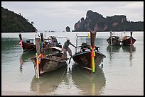 Man stepping on boats, Ao Lo Dalam, Ko Phi-Phi Don. Krabi Province, Thailand ( color)