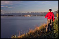 Man walking on the edge of Knik Arm in Earthquake Park, sunset. Anchorage, Alaska, USA (color)