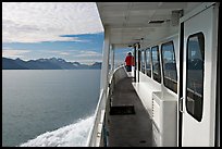 Passenger standing outside tour boat. Seward, Alaska, USA