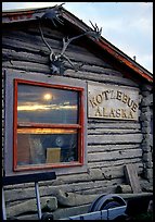 Log cabin with caribou antlers and sun reflected in window. Kotzebue, North Western Alaska, USA