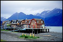 Stilt houses on the Spit, Kenai Mountains in the backgound. Homer, Alaska, USA