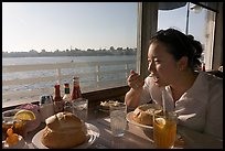 Woman eating clam chowder in a sourdough bread bowl. Santa Cruz, California, USA (color)